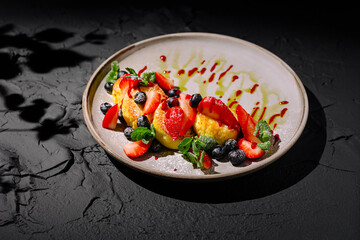 Fluffy cottage cheese pancakes served with fresh strawberries, blueberries, mint, and berry sauce. A vibrant and delicious dessert or breakfast option.