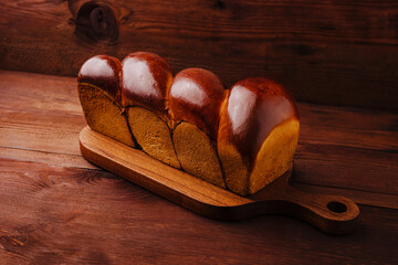 Freshly baked golden bread on a wooden serving board ready to enjoy