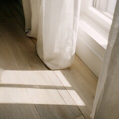 Sunlight streams through sheer white curtains onto light-toned wood floors