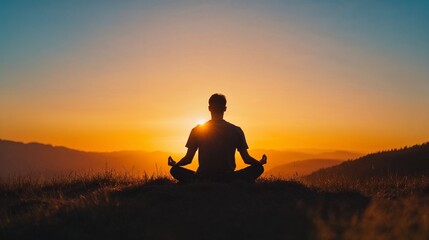 Man meditating at sunrise on mountain peak