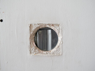 Hole where a light switch used to be in a plasterboard wall. Sliding door installation.