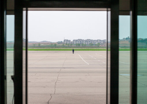 North Korean airport employee on the tarmac in Sunan international airport, DGC, Pyongyang, North Korea