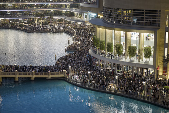 Dubai, United Arab Emirates - 16 June 2025: Aerial view of crowds thronging the waterfront promenade near the Dubai Mall, reflecting vibrant lights on the water.