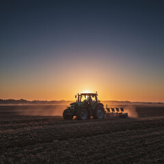 Obraz premium Golden Sunrise Tractor Plowing Field: Rural Landscape in High Detail, 8K Resolution.