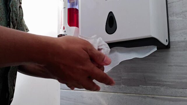 Hand Drying Hygiene Routine in a Public Restroom Cleanliness Focus.