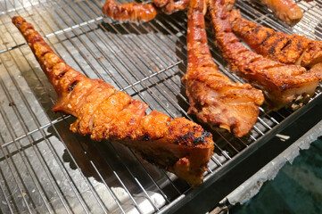 Crispy Grilled Pork Tails on Street Food Rack.