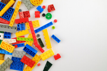 Scattered colorful plastic building blocks on a white background.