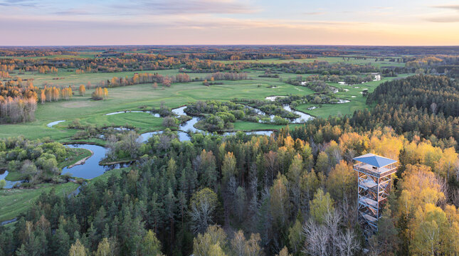 Aerial view to the sunset colored spring landscape of the Mustj&otilde;gi river valley, oxbows and meadows and public watchtower in Tellingum&auml;e, Tsirgum&auml;e k&uuml;la, Valga vald, Valgamaa