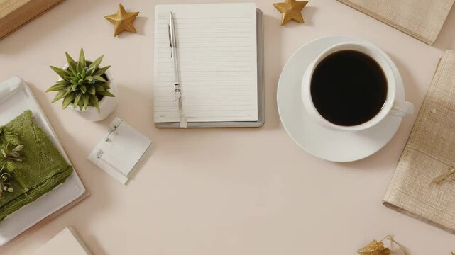 Minimalist workspace featuring coffee, notebook, plant, and christmas decorations, creating cozy atmosphere for work or study