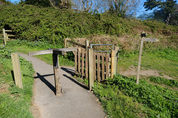 wooden turnstile and footpath sign in the countryside
