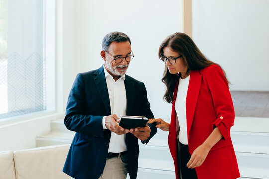 Senior professionals discussing business information during a meeting - Powered by Adobe