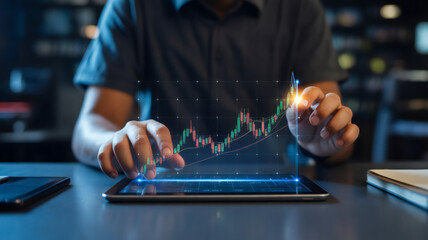 Fototapeta premium Person interacting with a holographic stock market graph on a tablet device