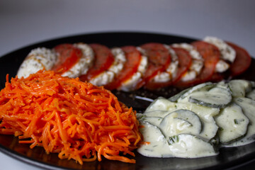 Vegetable platter; with Caprese salad, with tomato and cheese, mozzarella Di Buffalo and basil; there is also shredded carrot salad, and cucumber salad, with vinaigrette cream with mint.