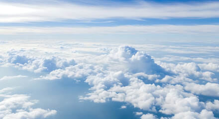 Fototapeta premium Aerial view above the clouds with a bright blue sky, fluffy white cloudscape stretching to the horizon, peaceful and serene atmosphere, soft lighting, natural sky scene