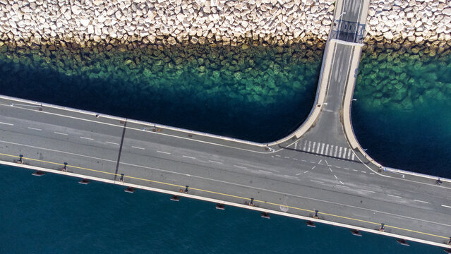Aerial view of the bridge cutting through crystalline waters, juxtaposed against the rugged shoreline, Split, Split-Dalmatia County, Croatia.