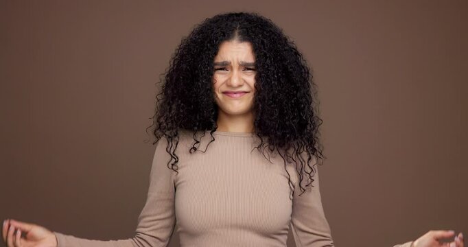 Hair care, confused and face of woman in studio with beauty, messy or damage for treatment. Upset, portrait and female person from Mexico with frizz for curly hairstyle fail by brown background.