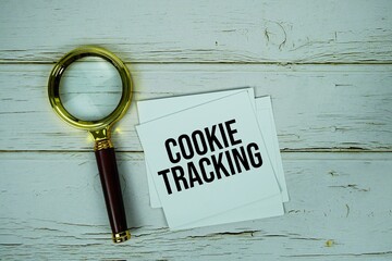 Cookie Tracking text message on paper with magnifying glass on wooden background