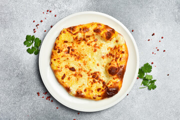 Georgian khachapuri with cheese. Pizza with cheese. On a stone background.