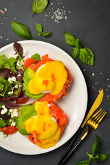 Bruschetta with salted salmon, avocado, cheese and poached egg. Sandwich. On a stone background. Close-up.