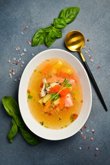 Seafood soup: salmon, sea bass with red caviar. In a white oval bowl. Close-up. Food rich in omega...