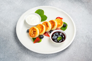 Breakfast. Cottage cheese pancakes with berries, jam and sour cream. Healthy meal.