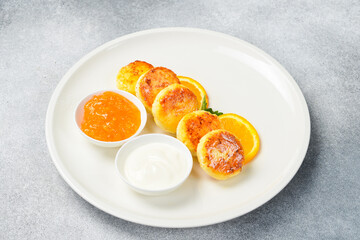 Breakfast. Cheese pancakes with orange jam and sour cream. Healthy meal.