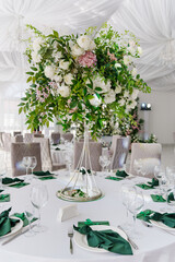 A composition of delicate flowers on the tables in the banquet hall.