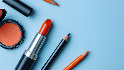 Flat lay showcasing cosmetic essentials, vibrant lipstick, blusher and makeup pencils on a calming blue background.