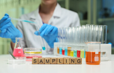 A laboratory setting vividly showcases a technician carefully sampling various chemicals contained...