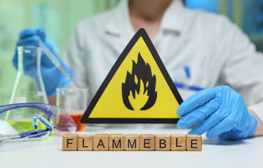 A lab scene with a flammable warning sign and various colorful chemical solutions on the countertop