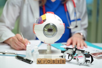 An eye model along with various examination tools utilized in ophthalmology specifically for...