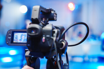 A professional videographer is filming a banquet hall event.