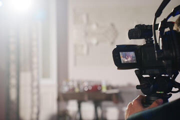 A professional videographer is filming a banquet hall event.