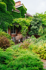 a house and a courtyard of a country house, braided with greenery.