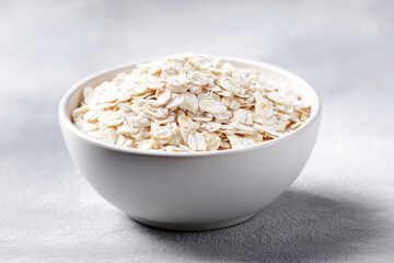 Bowl of flour, white finely ground substance, baking ingredient on light surface, ideal for cooking and recipe backgrounds.