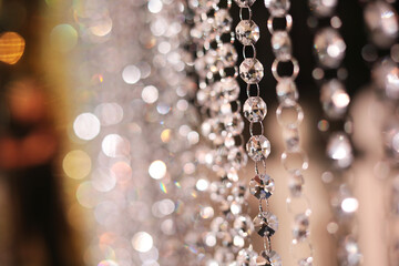 Close-up of crystal beads or decorative hanging garlands with beautiful bokeh lights in the...