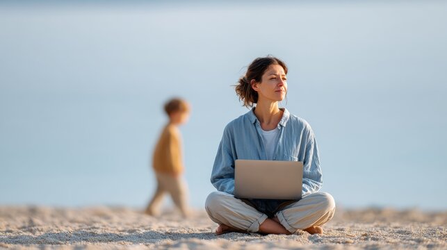 Freelancer mother is working remotely on the beach using her laptop, while her child is playing nearby, demonstrating work life balance and the digital nomad lifestyle