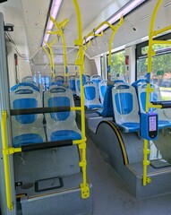 Filas de asientos azules vacíos dentro de un moderno autobús de transporte público.