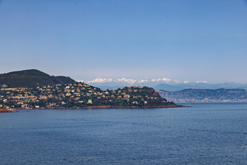 Cliffs on the Cote d'Azur, French Riviera, with Cannes and snow-capped mountains in the background