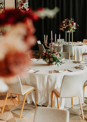 Elegant wedding reception table setting with floral centerpiece and tall candleholders.