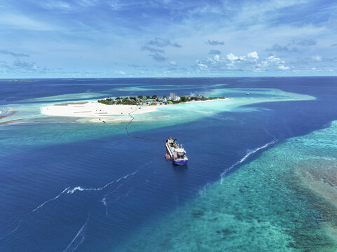 Aerial view of a vessel dredging sand from the ocean floor, Gulhi, Kaafu Atoll, Maldives.