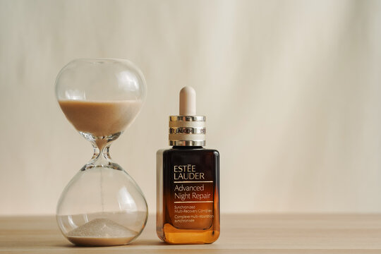 Strasbourg, France - June 2025 : Estee Lauder advanced night repair face serum shot on next to hourglass on beige background. Luxury skincare reverses age