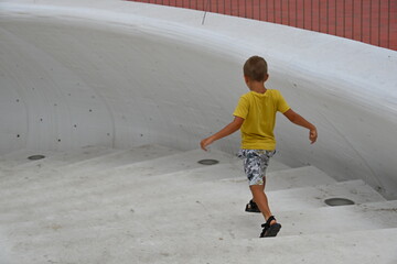 mały chłopiec w żółtej koszulce schodzi białymi schodami na plaże  © Miroslaw