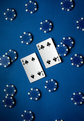 Two playing cards, both showing fours, sit center stage surrounded by an array of blue poker chips, representing a vibrant gaming experience during a lively casino night