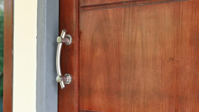 A woman's hand is knocking on the door