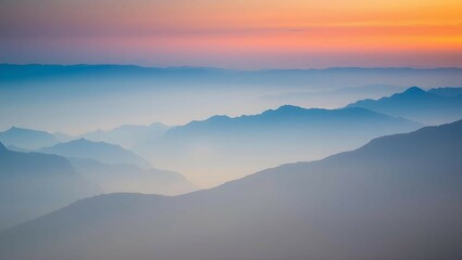 Obraz premium Wide scenic mountain wallpaper featuring moody peaks in layered blue and orange tones with soft haze – minimalist natural background for calm desktop visuals, artistic landscapes, and creative design 