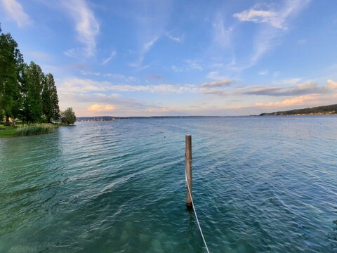 Tranquil Lakeside View at Sunset with Clear Blue Water and Scenic Sky