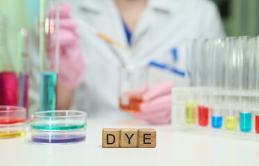 A scientist works with vibrant chemical dyes in a laboratory setting, showcasing various colorful...