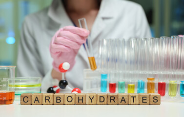 A skilled lab technician carefully analyzes various carbohydrates by using test tubes and chemical...