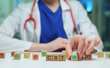 A healthcare pro arranging blocks to represent CBT, emphasizing the importance of mental health treatment